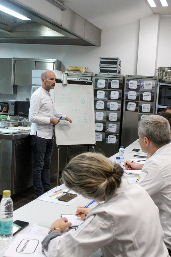 Martin Lippo working through theory at the flip chart while cooks take notes