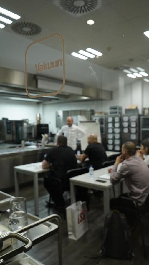 The Vakuum teaching kitchen seen through the glass, a session under way