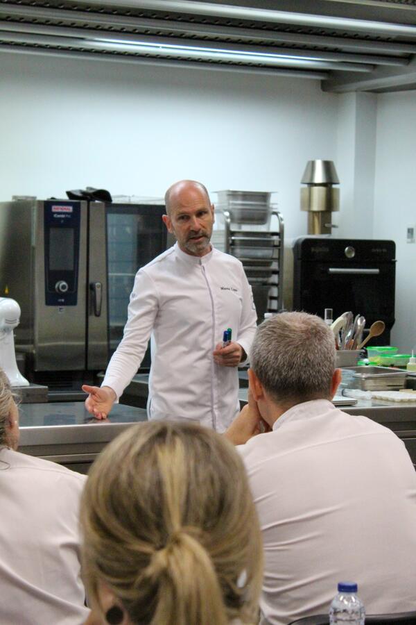 Martin Lippo talking a technique through to seated cooks in the Vakuum kitchen, Barcelona
