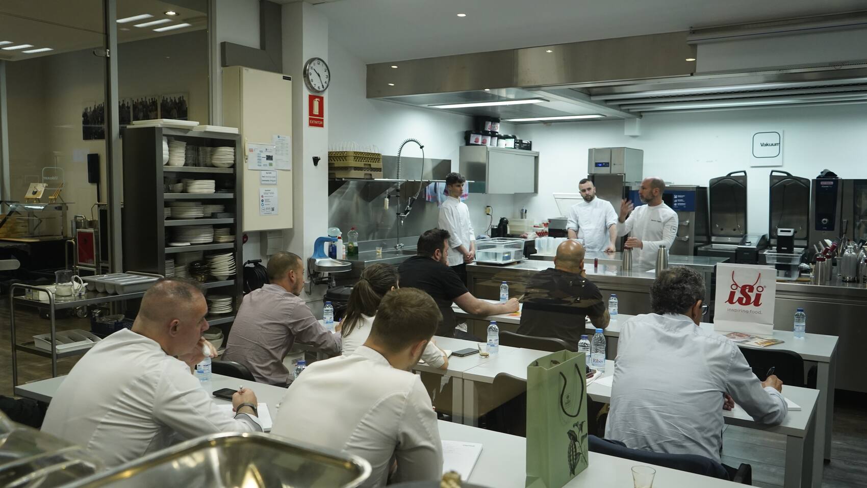 A full room of professional cooks seated at the benches while Martin Lippo teaches at Vakuum, Barcelona