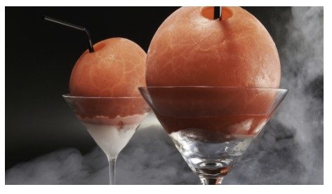 Nitro sorbet spheres in martini glasses, nitrogen fog