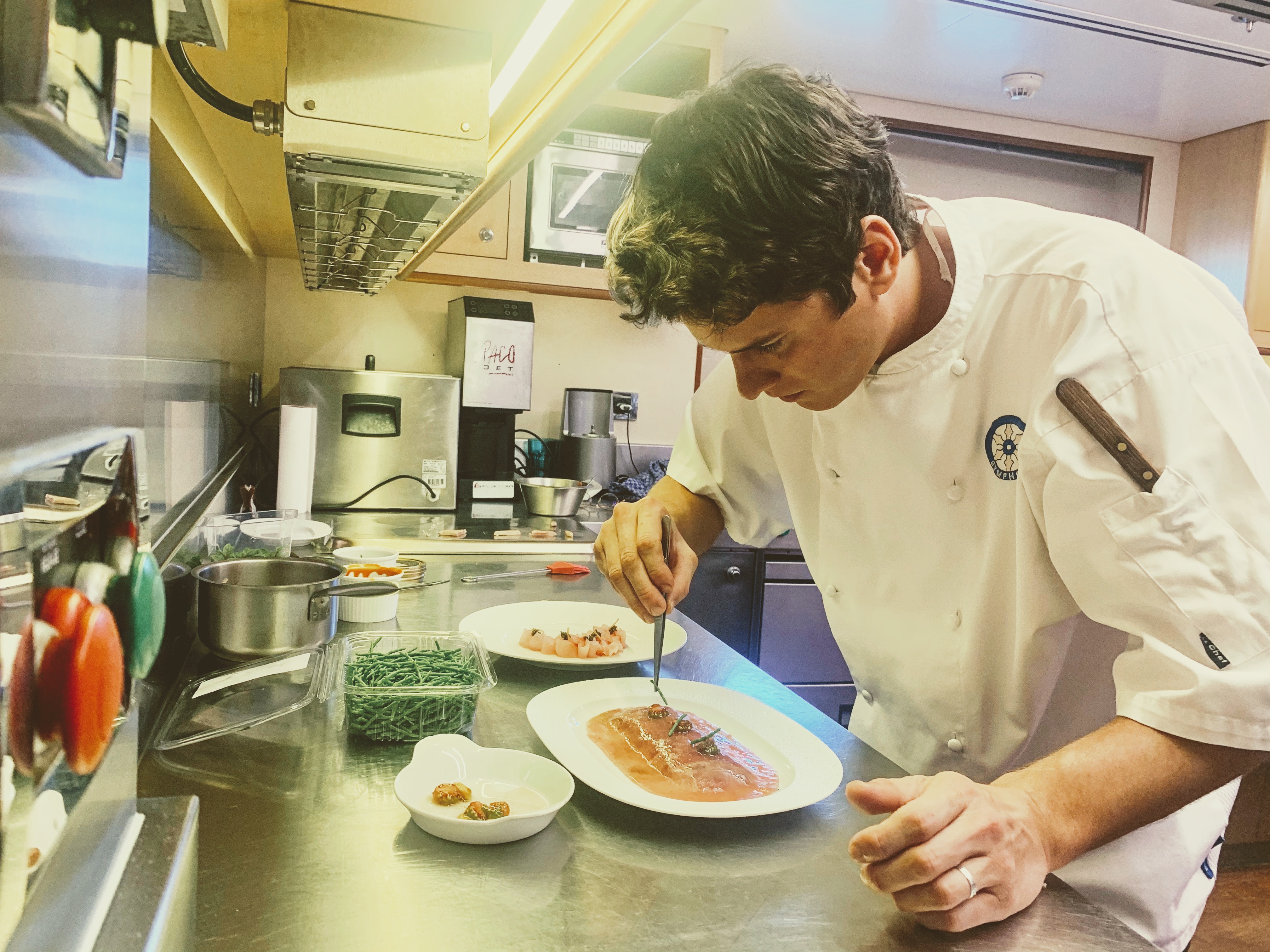 Chef plating in a working galley
